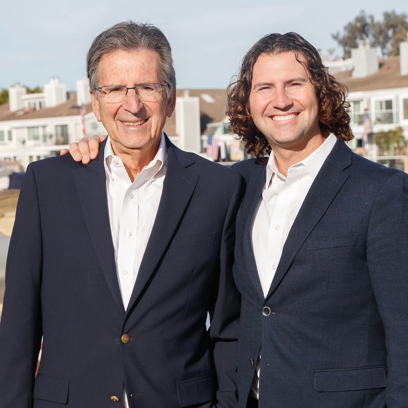Justin Ratowsky with his hand on his father Craig Ratowsky's shoulder, the father-son team at Ratowsky Group at Compass in Huntington Beach.