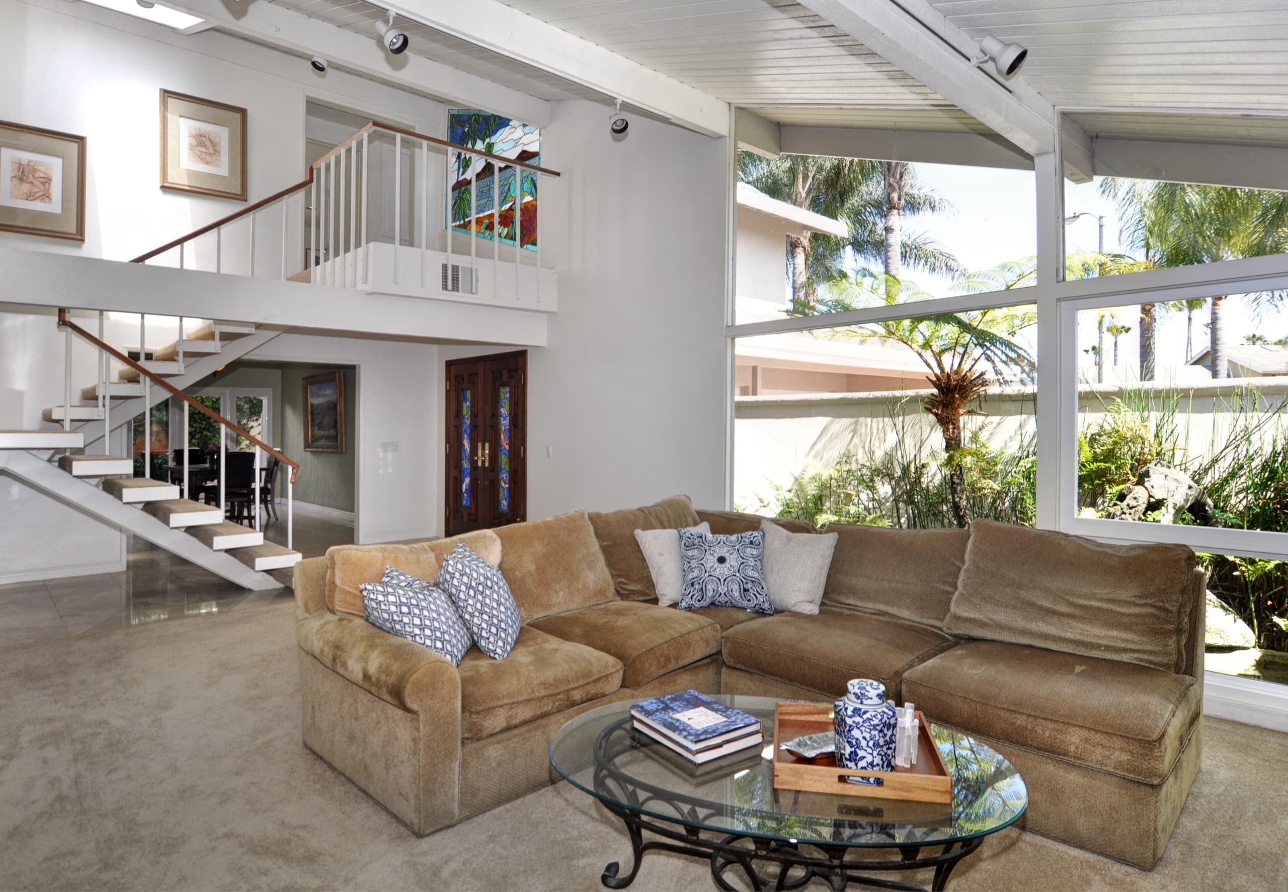 A bright living room under a vaulted open-beam ceiling in a Huntington Harbour home.
