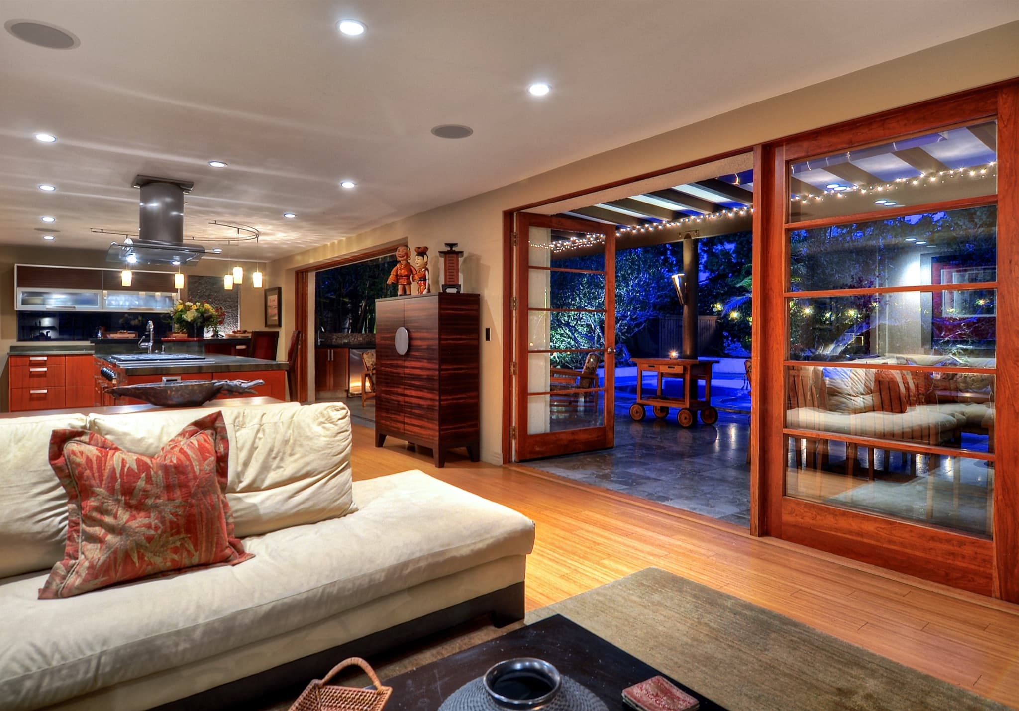 A warm twilight living room opening to a coastal patio in a Huntington Beach home.