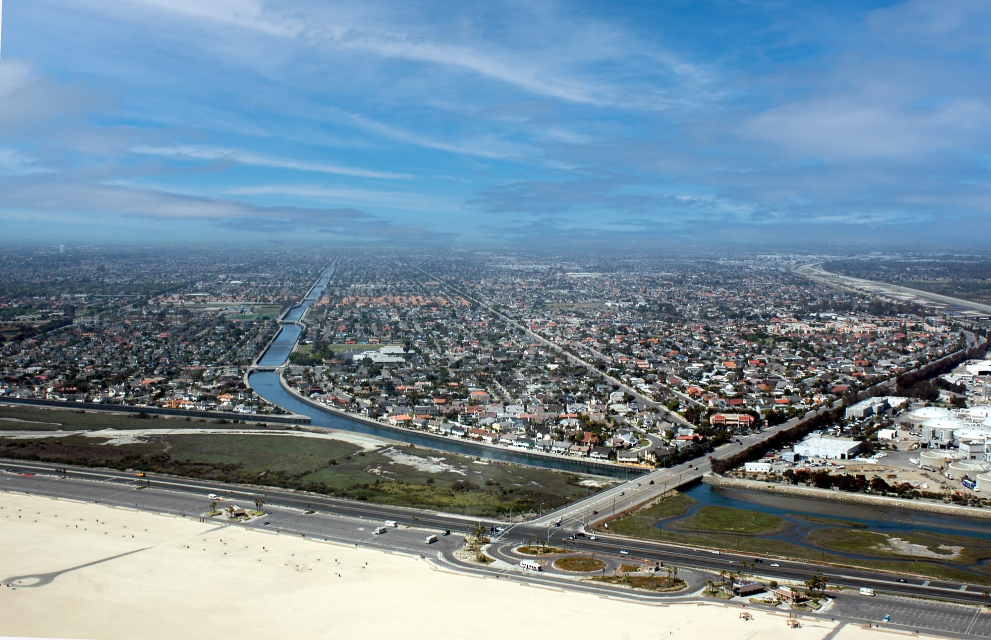 Aerial of Brookhurst Street at Pacific Coast Highway, with the Talbert channel, beach and south Huntington Beach neighborhoods.