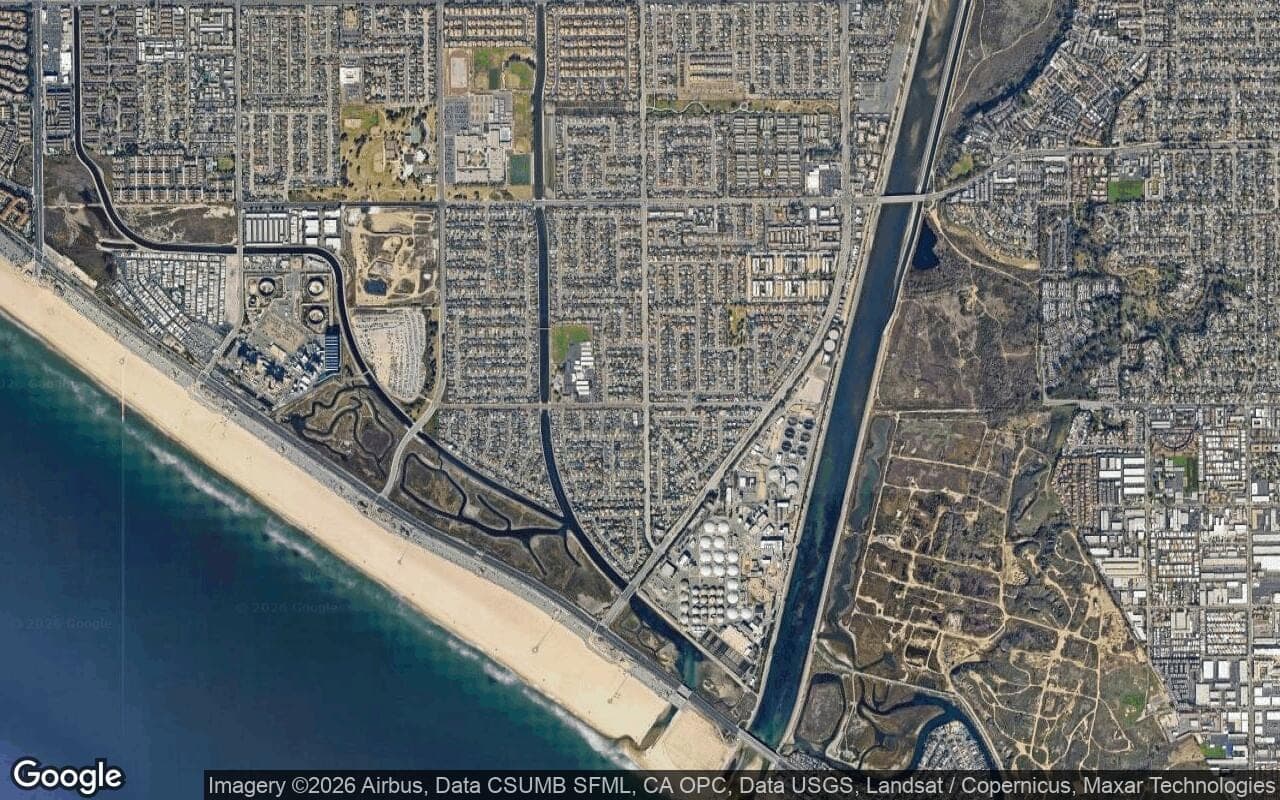 Satellite aerial of south Huntington Beach neighborhoods between Adams Avenue, the Santa Ana River channel, and the state beach.