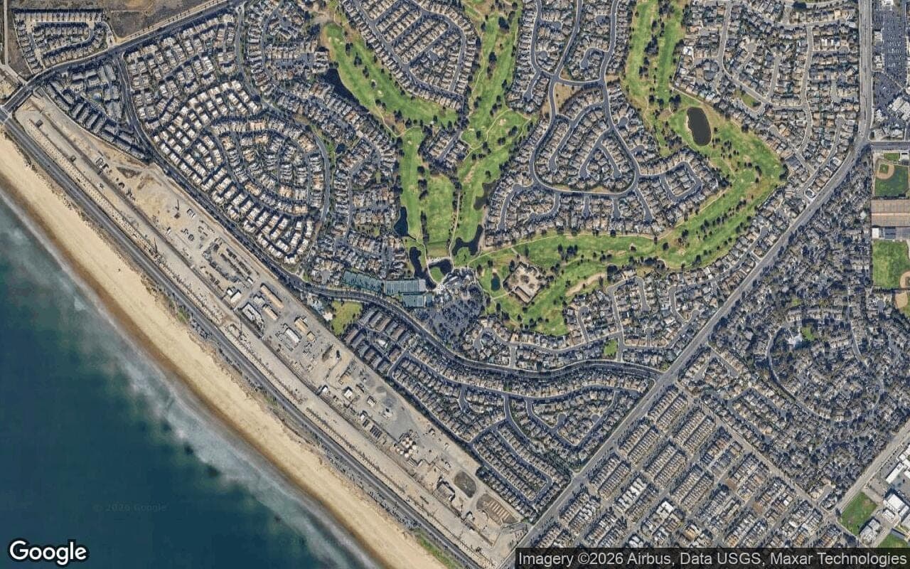 Satellite aerial of the Huntington Club golf course threading through the Seacliff neighborhoods of Huntington Beach, with the Pacific Ocean to the west.
