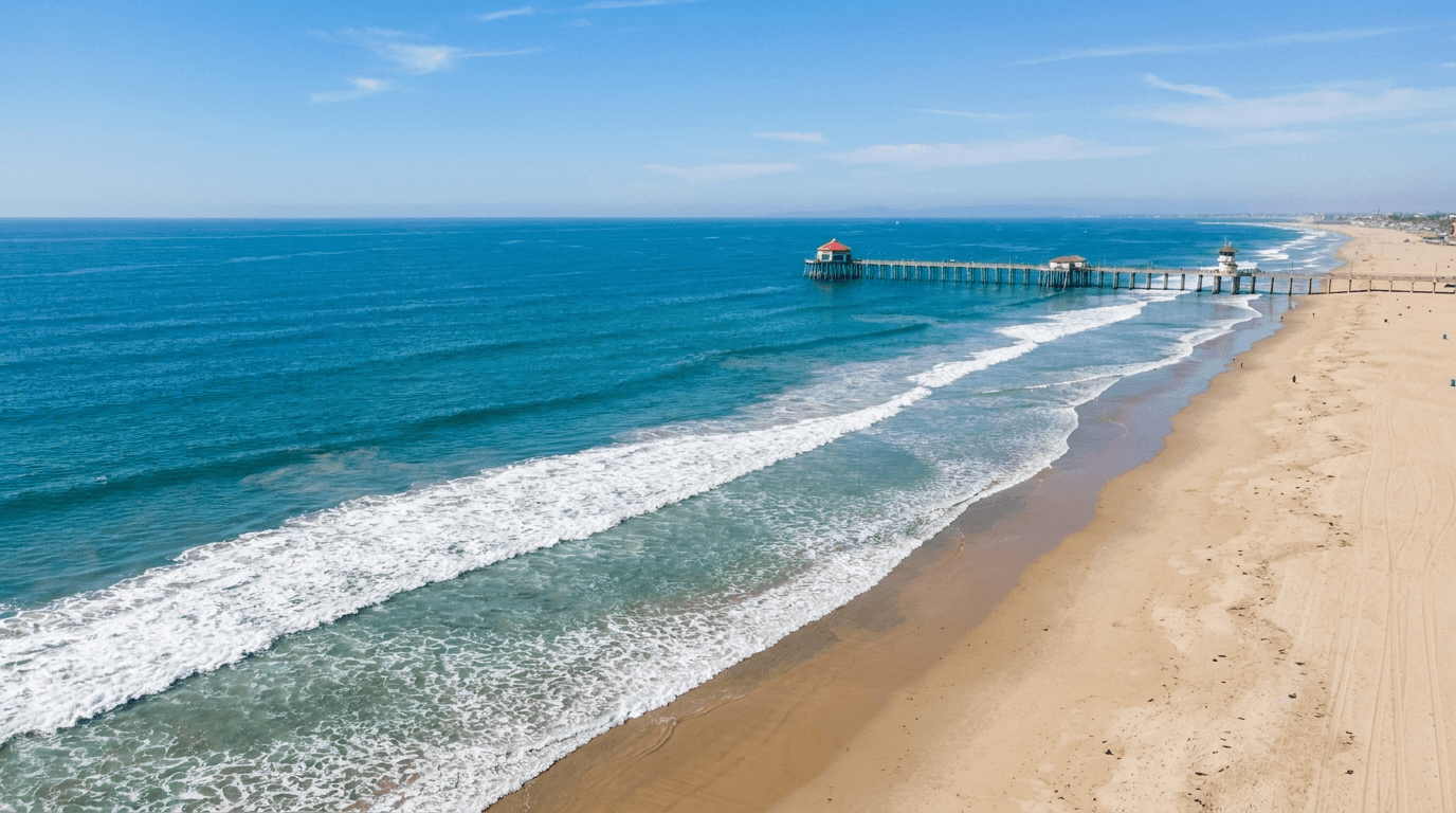 Aerial view down the Huntington Beach coastline, sandy shore beside the turquoise Pacific.