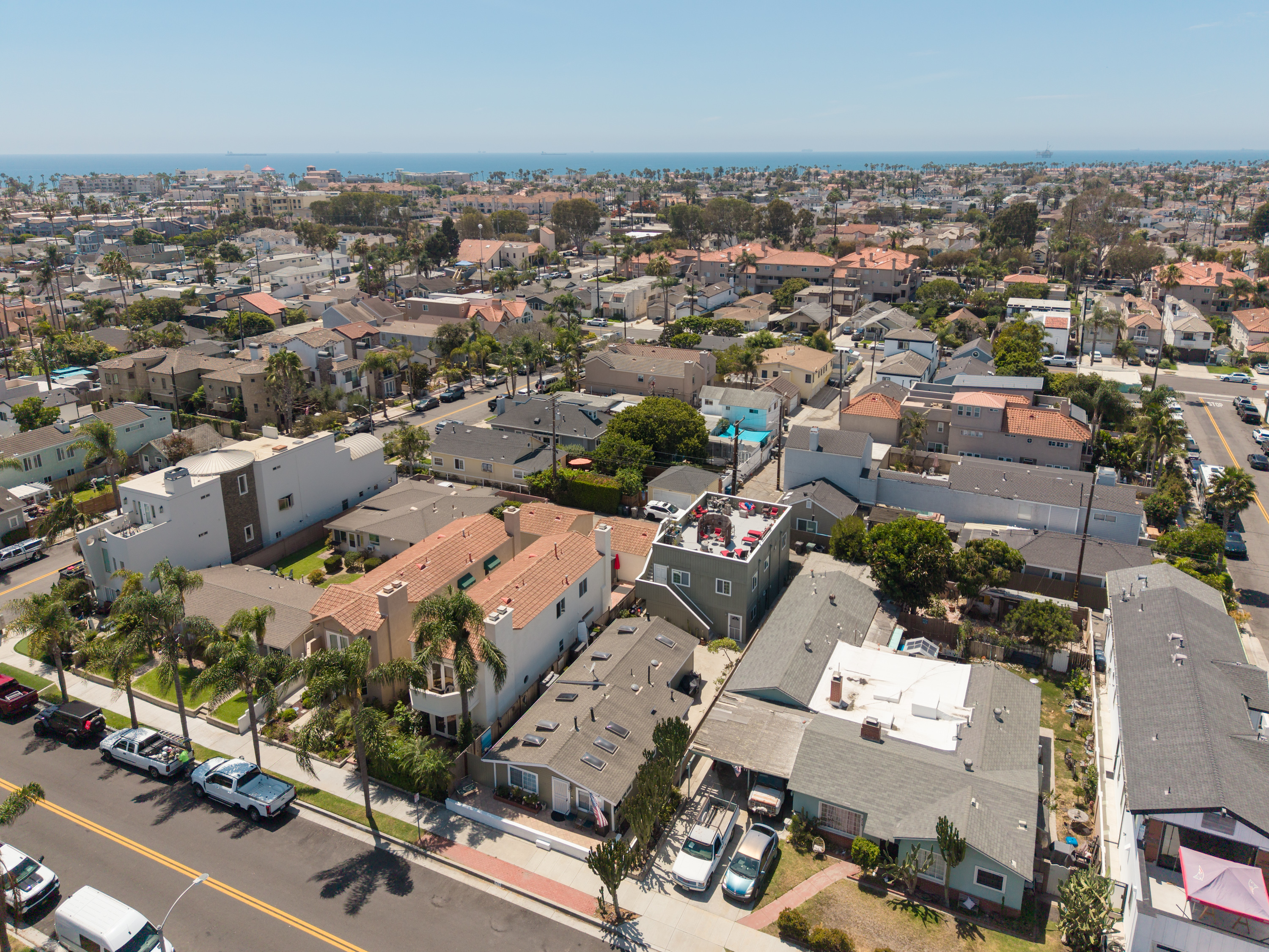 Aerial view of 711 Huntington Street's rooftop deck with the Pacific Ocean and Downtown Huntington Beach in the background.