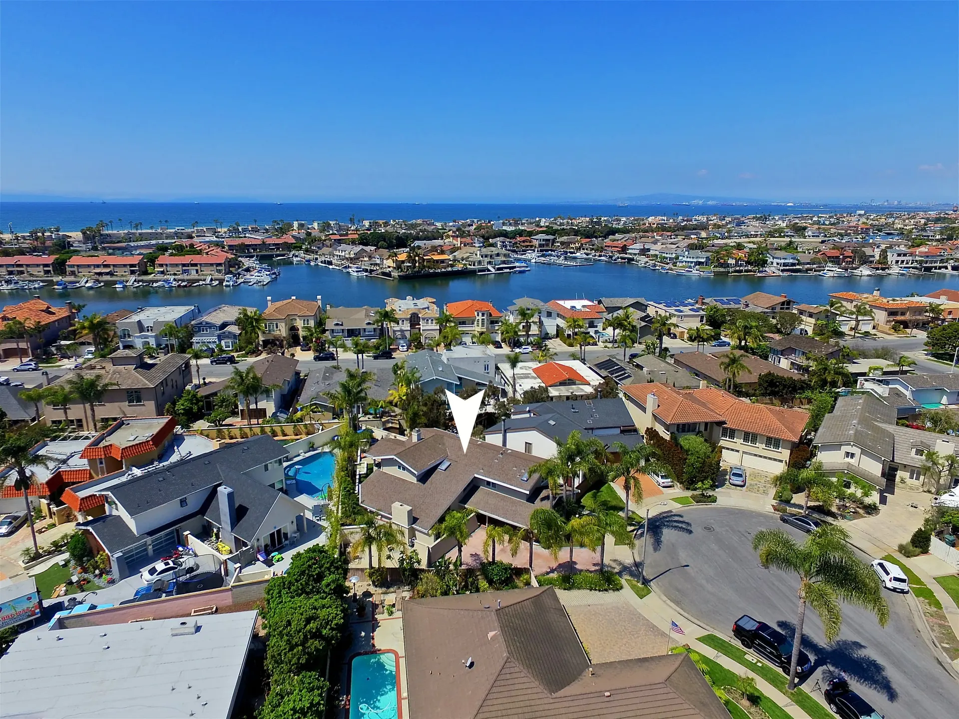 Aerial of Huntington Harbour waterfront homes on Legend Circle with private docks along the channel.